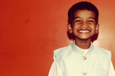 Portrait of a smiling young man against wall