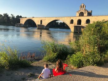 Rear view of people on bridge over river