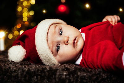 Close-up portrait of cute baby boy wearing santa costume during christmas