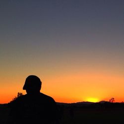 Silhouette of people on landscape at sunset