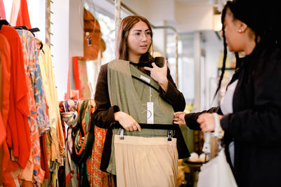 Female friends talking while shopping at retail store