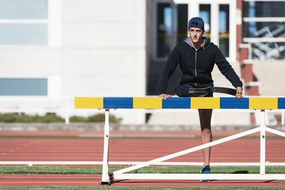 Man with prosthetic leg standing on running track