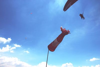 Low angle view of a man jumping against blue sky