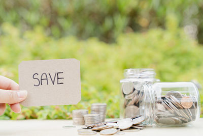 Close-up of hand holding paper with text on table