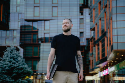 Portrait of man standing against buildings