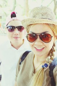 Close-up portrait of female friends wearing sunglasses while standing outdoors