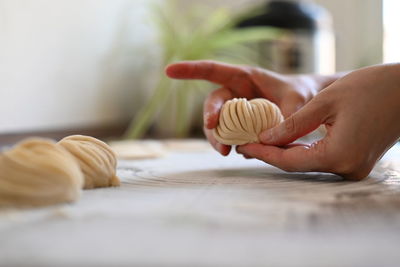 Cropped hand of woman holding food on table