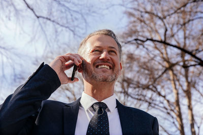 Successful smiling business man, professor, in university park, academic building	