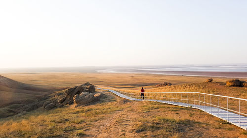 Mid distance view of man walking on footpath at desert