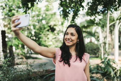 Beautiful girl taking a selfie in the greenhouse
