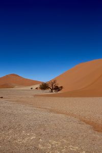 Scenic view of desert against clear blue sky