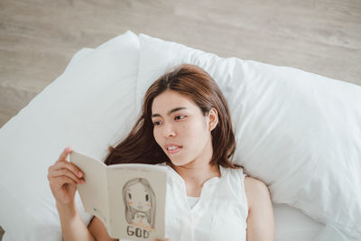 Portrait of woman lying on bed at home