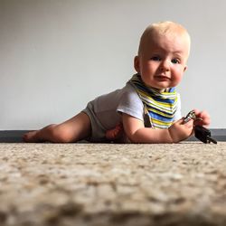 Portrait of cute baby holding key at home