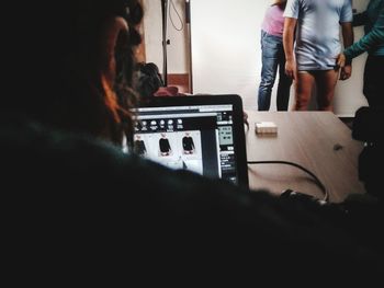 Rear view of people using laptop