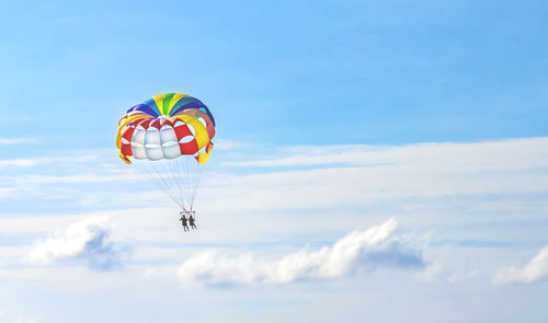 Low angle view of person paragliding against sky