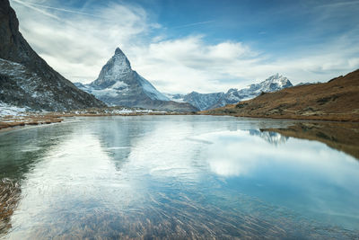 Scenic view of lake and mountains against sky