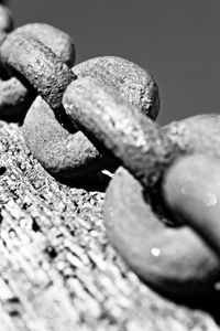 Close-up of rusty metal chain on wood