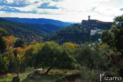 Scenic view of trees and mountains against sky