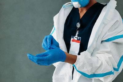 Midsection of woman removing gloves