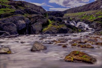 Scenic view of waterfall against sky