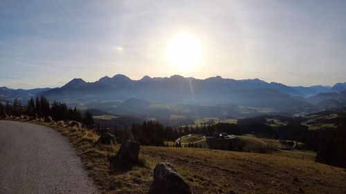 Scenic view of road by mountains against sky