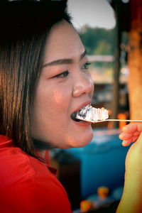 Close-up portrait of woman eating food at restaurant