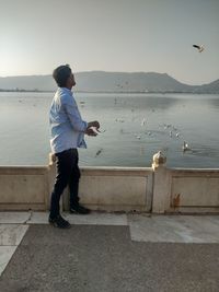 Full length of man standing on sea shore against sky