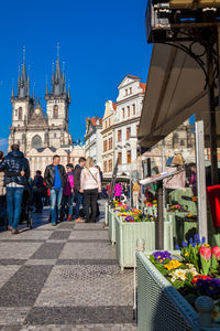 People walking on street against buildings in city