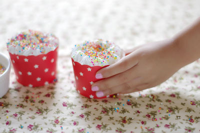 Cropped hand of woman holding cupcake