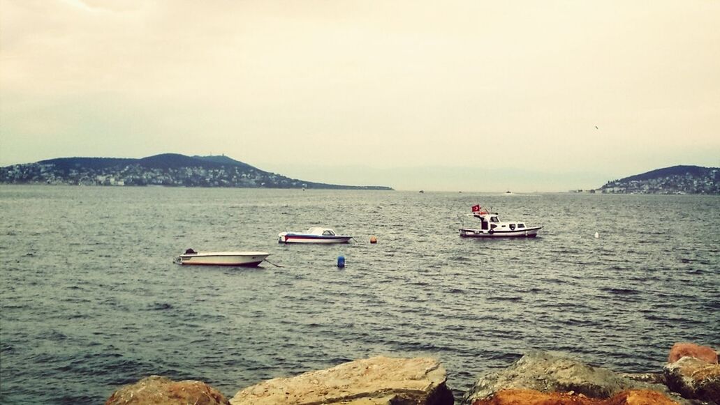 nautical vessel, transportation, water, boat, mode of transport, sea, mountain, scenics, tranquil scene, tranquility, waterfront, beauty in nature, nature, rippled, sky, sailing, travel, day, outdoors, copy space