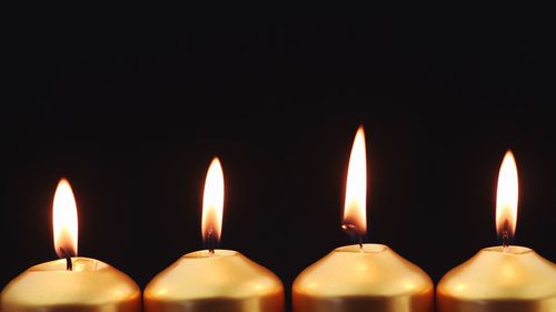 Close-up of lit candles in the dark