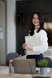 Portrait of smiling woman standing at home