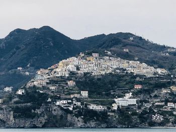 Townscape by mountain against sky