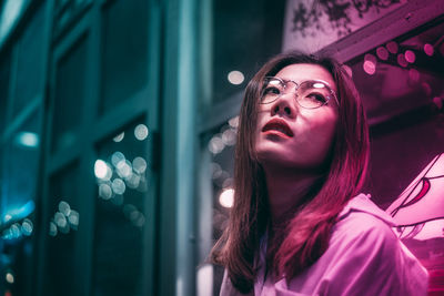 Portrait of beautiful young woman looking away at night