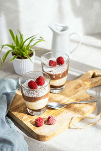 Three-layer mousse dessert made of chocolate and vanilla, decorated with fresh raspberries