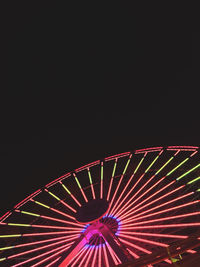 Low angle view of illuminated ferris wheel against sky at night