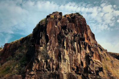 Low angle view of rock formation against sky