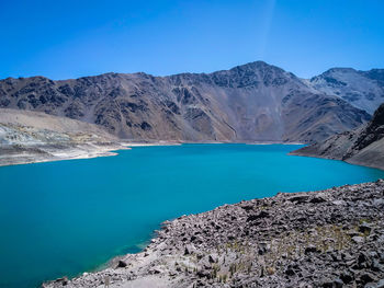 Scenic view of lake and mountains against blue sky