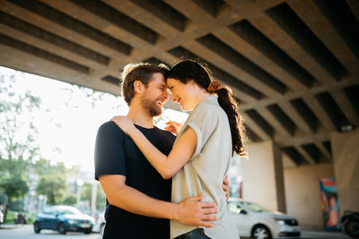 Happy couple standing by car