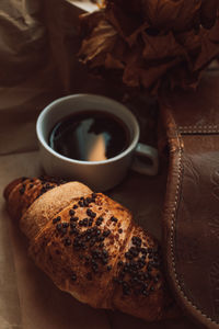 A cup of black morning coffee with a chocolate croissant. delicious meal. aesthetics 