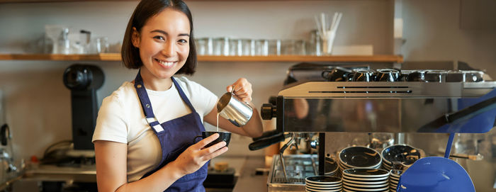 Portrait of young woman drinking coffee in gym