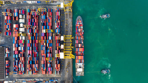 Aerial view tugboats assisting container ship to international commercial dock, global business