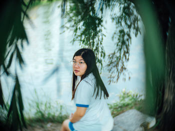 Portrait of woman standing by plants