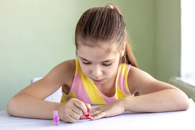 Side view of young woman using laptop while sitting on table
