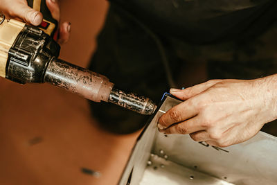 Cropped hand of man repairing pipe