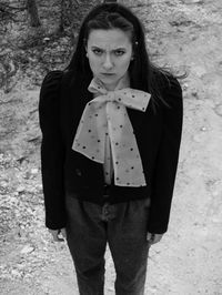 Portrait of young woman standing on field