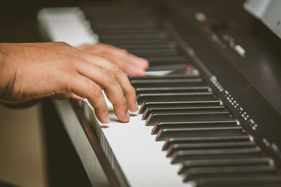 Cropped hands of man playing piano