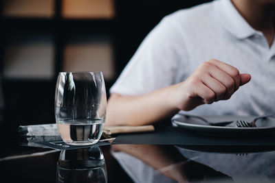 Close-up of man drinking glass on table