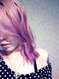 Close-up of young woman standing against gray background