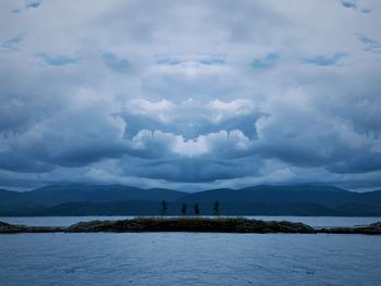 Nordic landscape, along a mysterious lake with a dramatic sky, cold weather, clouds, blue 